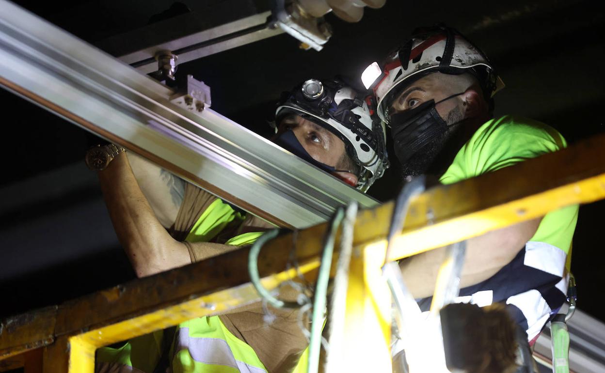 Dos operarios de Adif trabajan en la catenaria.