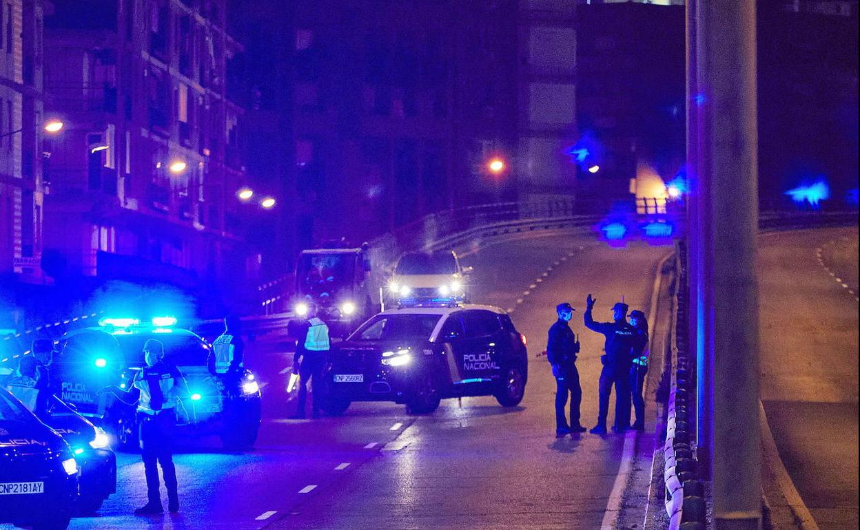 Un control de policía nocturno vigila el cumplimiento del toque de queda.