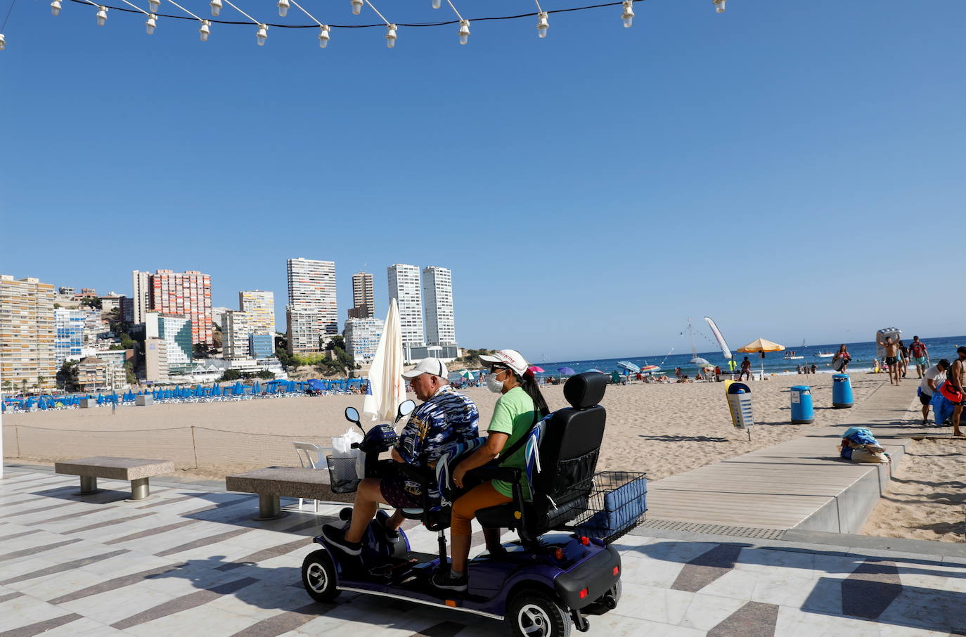 Finales de julio y mucho calor en Benidorm. Menos turistas de lo normal por culpa del Covid. Predominan los visitantes nacionales y algunos británicos se dejan ver por los lugares de ocio habituales. A partir del lunes, toque de queda, como en otros 76 municipios de la Comunitat Valenciana. 