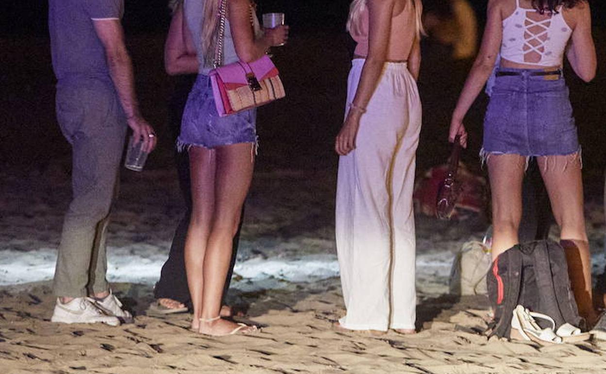 Jóvenes en la playa de Valencia por la noche. 