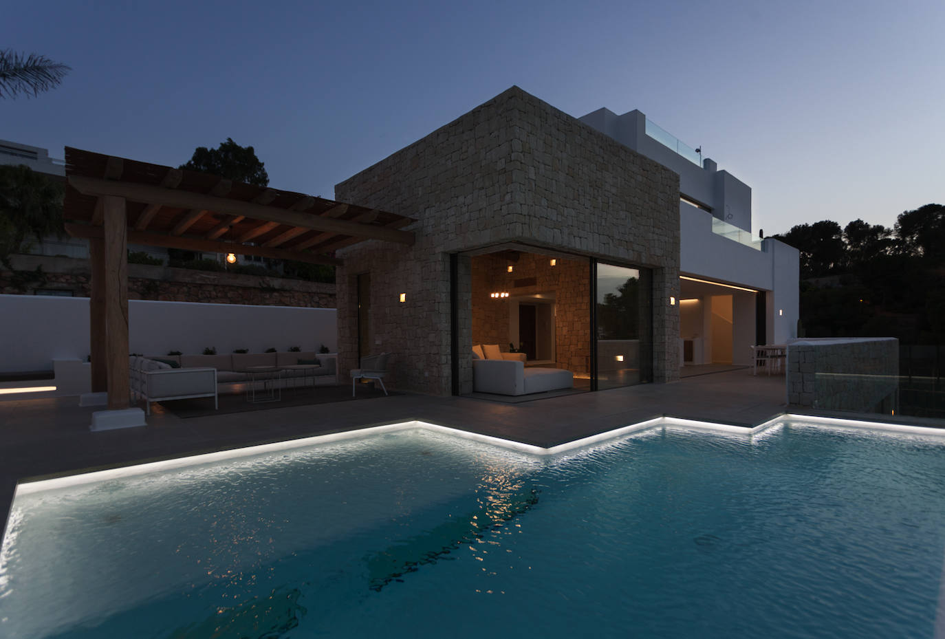 Vista exterior de la vivienda, con la iluminación nocturna.