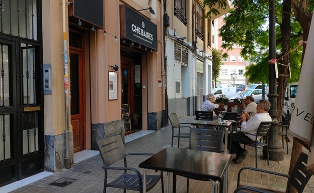 Imagen principal - Arriba, terraza del restaurante Che Baires. Abajo a la izquierda, fachada del restaurante. Abajo a la derecha, detalle de las macetas en la terraza del Che Baires. 