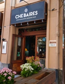 Imagen secundaria 2 - Arriba, terraza del restaurante Che Baires. Abajo a la izquierda, fachada del restaurante. Abajo a la derecha, detalle de las macetas en la terraza del Che Baires. 