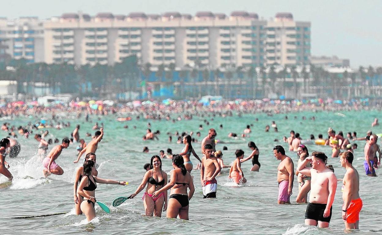 Un grupo de jóvenes disfruta del baño hace una semana, en la playa valenciana de la Malvarrosa. 