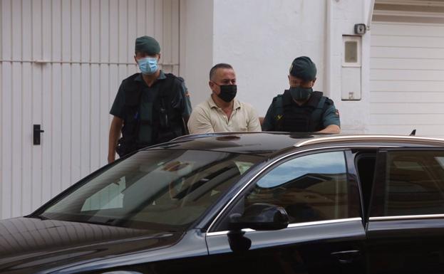 Dos guardias civiles trasladan al detenido. 