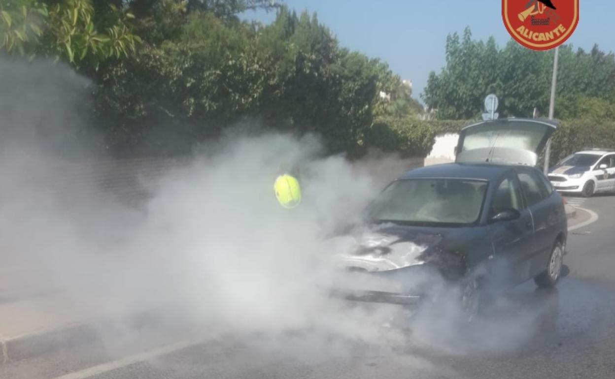 Los bomberos trabajan en la extinción del incendio del vehículo en Alicante. 