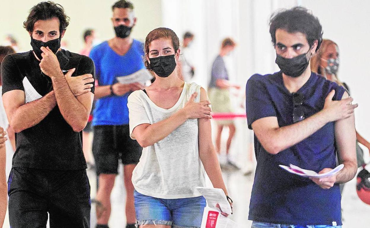 Varios jóvenes tras recibir la primera dosis de la vacuna en la Ciudad de las Artes y las Ciencias.