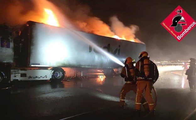 Varios bomberos durante la extinción del incendio del trailer. 