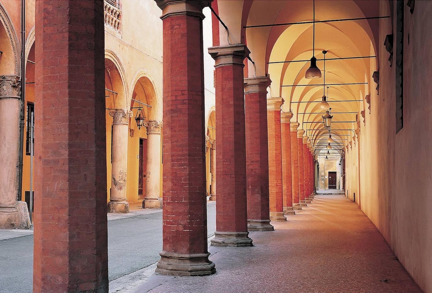 12.- LOS PÓRTICOS DE BOLONIA | La capital de la Emilia-Romaña cuenta con un total de 40 km. de pórticos, considerados los más largos del mundo. Ubicados en el segundo casco antiguo medieval más grande de Europa, solo superado por el de Venecia, estos pórticos siguen una estructura que nació en la baja Edad Media por el aumento de la población, fruto de la llegada de estudiantes e intelectuales a la Universidad de Bolonia. Los pórticos son un tipo de balcón de madera construido en la fachada de los edificios para disponer de un espacio mayor en los pisos altos, aunque debido al clima, los soportales se han convertido en un refugio que permite visitar la ciudad de forma más cómoda. 