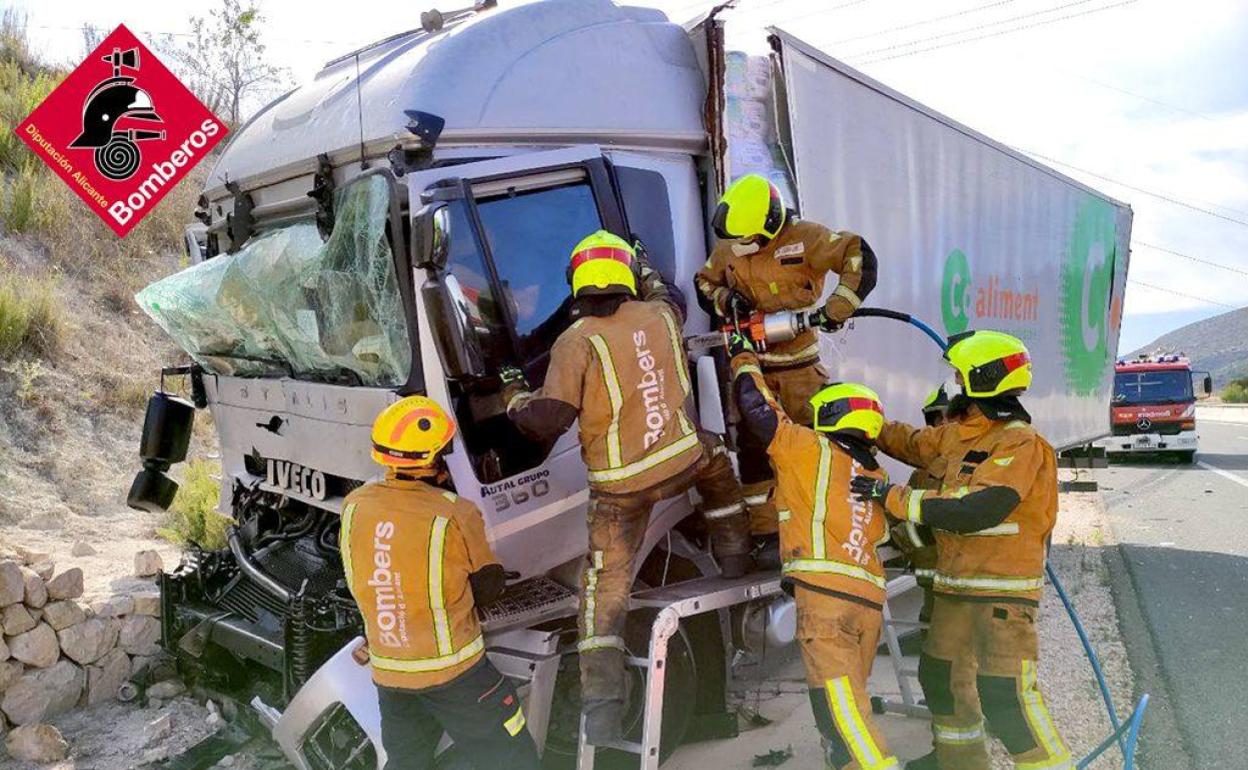 Los bomberos liberan al conductor atrapado en la cabina tras el accidente. 