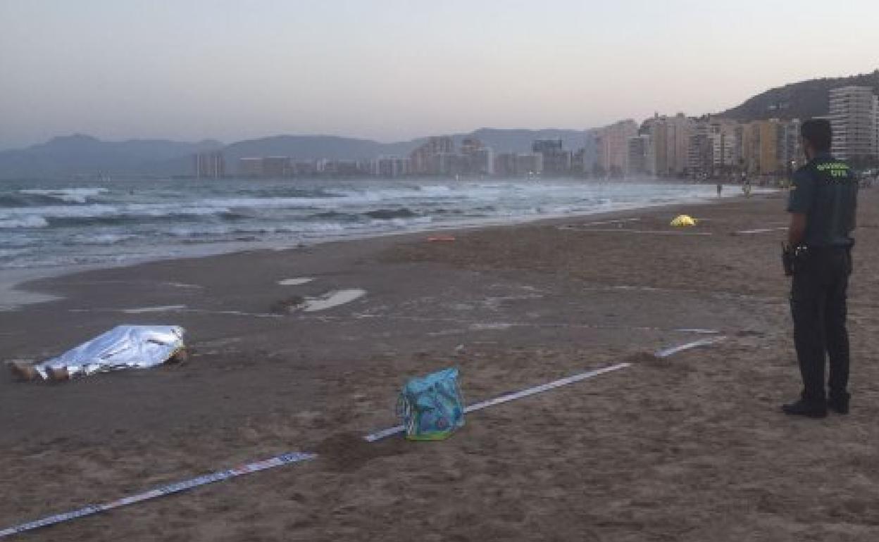 Un guardia civil junto al cadáver de un bañista en la playa de Cullera. 