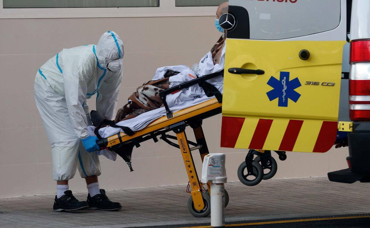 Un sanitario traslada a un enfermo en el Hospital Clínico de Valencia.