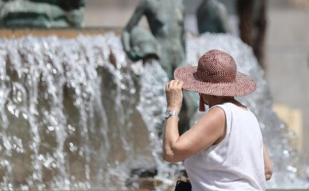 Una mujer se protege del calor en el centro histórico de Valencia. 