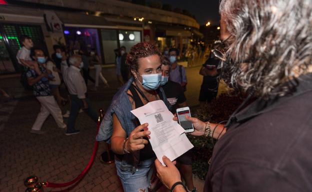 Una mujer muestra su certificado covid en Sanxenxo.