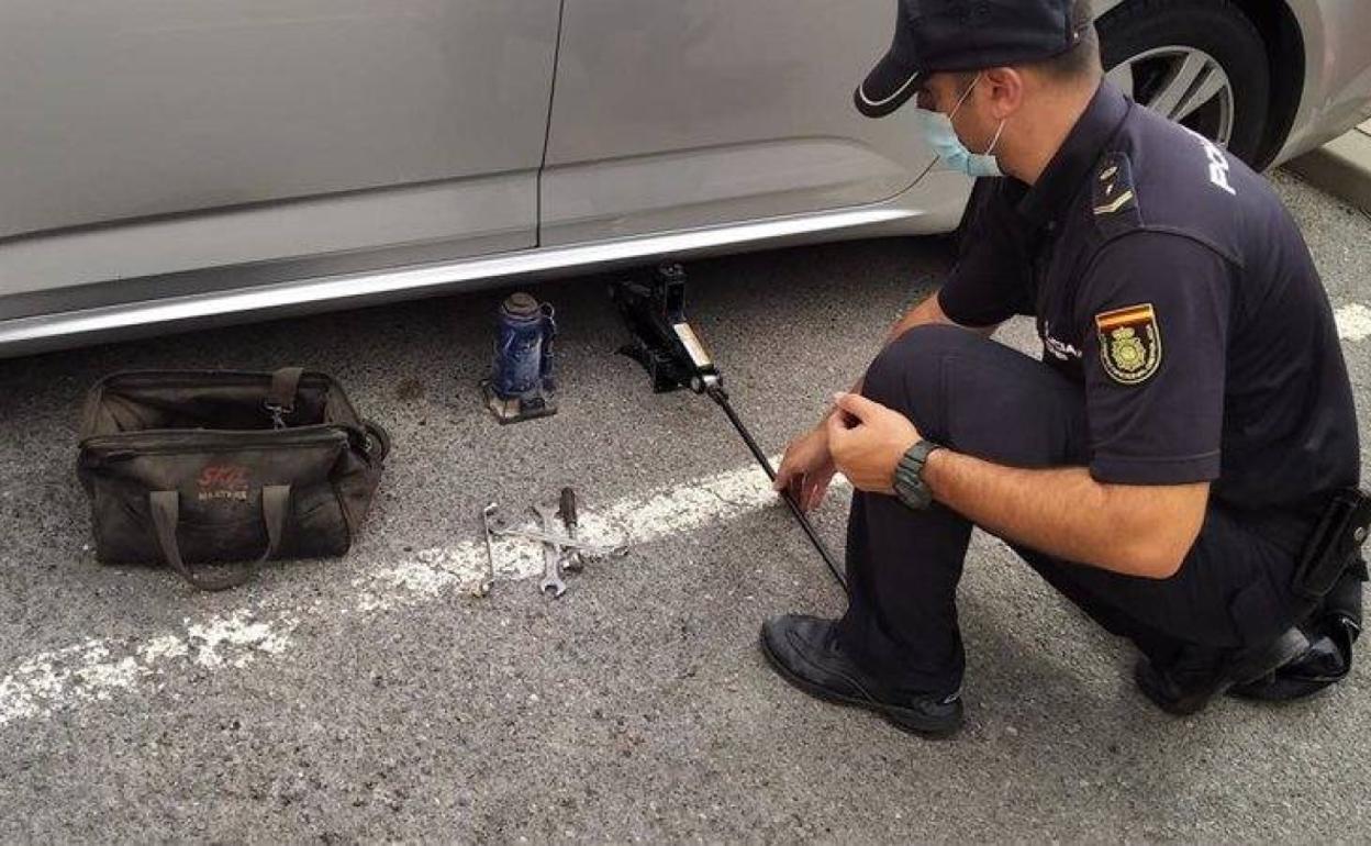 Un agente muestra uno de los gatos instalados por los detenidos. 