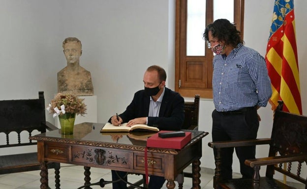 Imagen principal - Martínez Dalmau firma en el Libro de Oro de la localidad. 