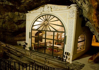 Imagen secundaria 1 - Arriba, a mano derecha, una de las estaciones de la romería hasta la Cueva Santa. Abajo a la izquierda, el santuario de la gruta. Abajo a la derecha, el sendero hasta la entrada del santuario. 