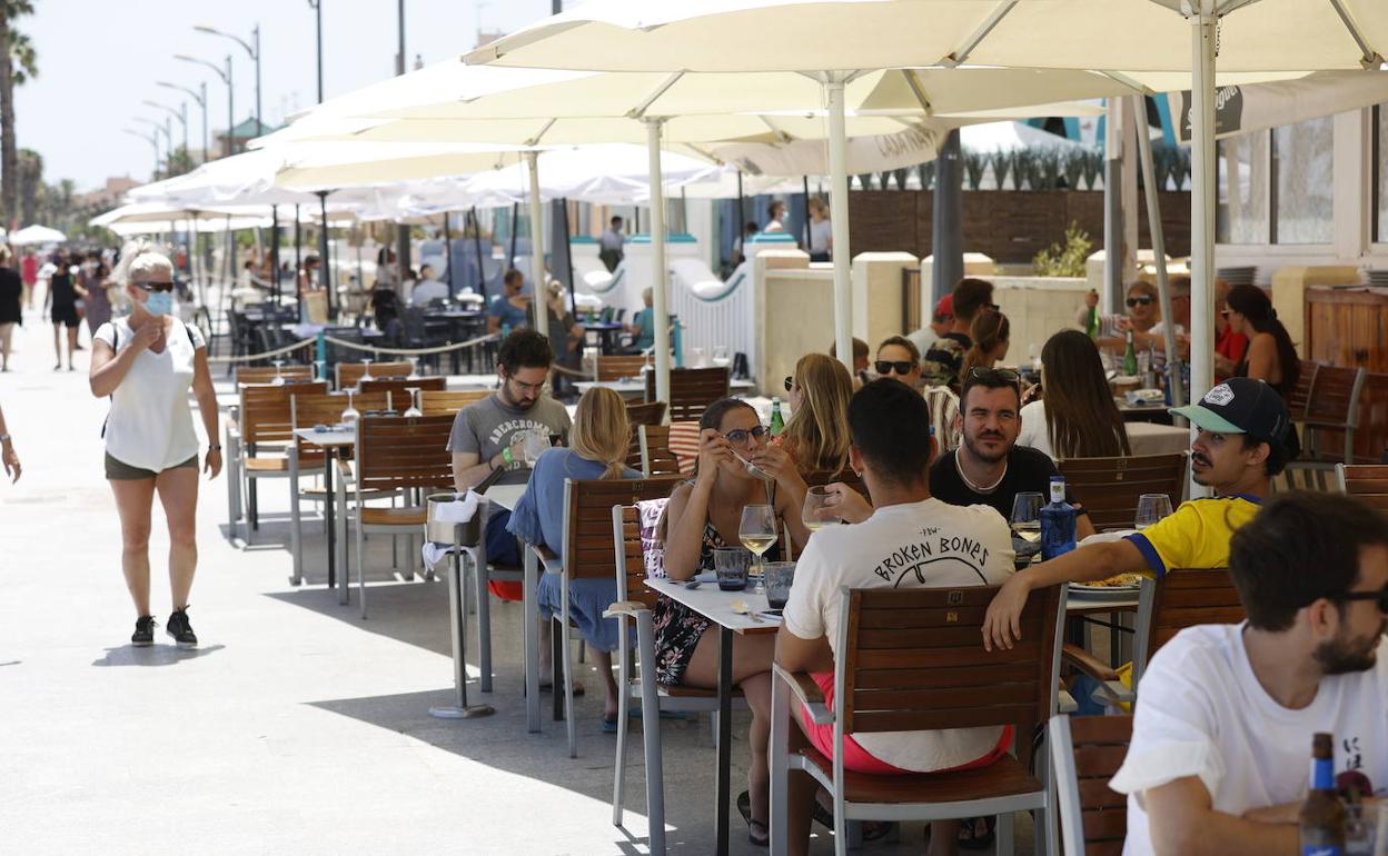 Terrazas con clientes en la playa de Valencia. 