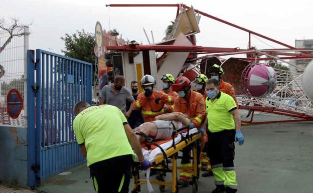 Los sanitarios trasladan a un herido tras caer la noria de Gandia.