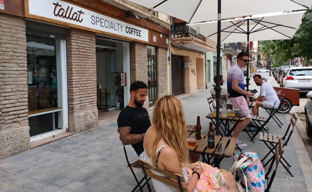 Imagen principal - Arriba, la terraza del Tallat Specialty Coffee. Abajo a la izquierda, bicicleta que utilizan en la cafetería para repartir los pedidos. Abajo a la izquierda, la terraza del Tallat. 