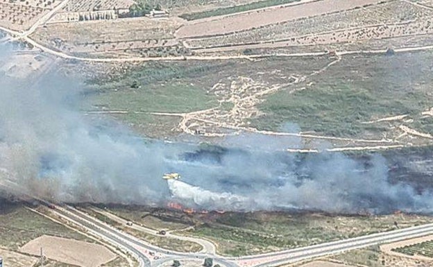 Una avioneta descarga agua durante la extinción del incendio en Pinoso, este martes. 