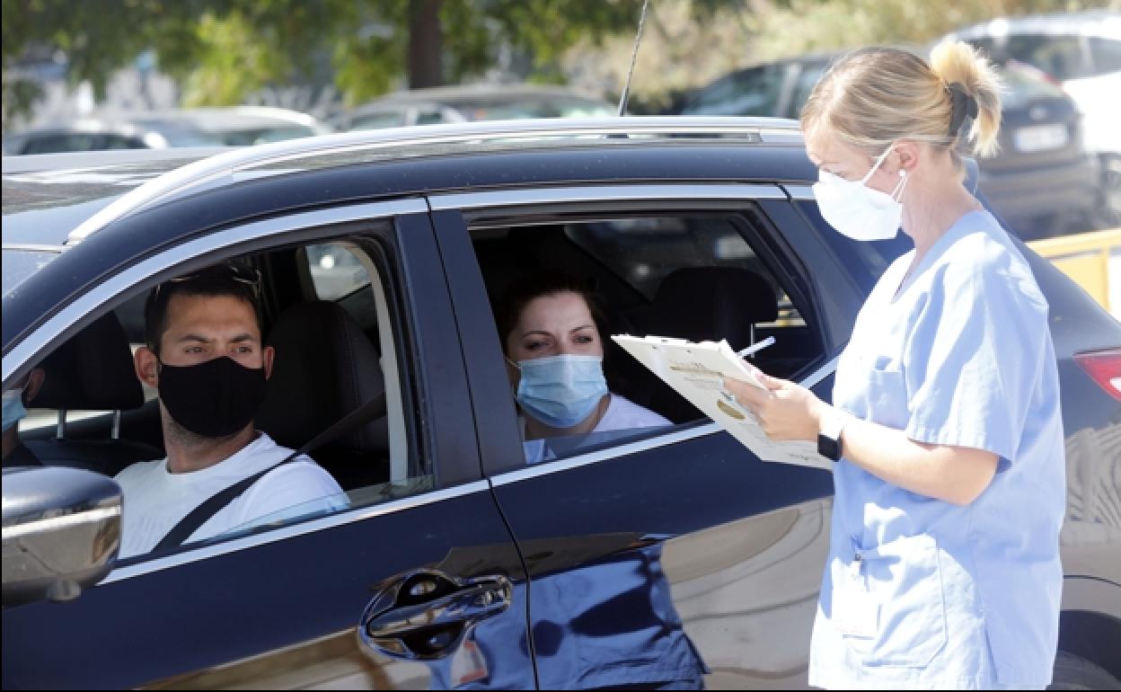 Dos personas esperan su turno para una PCR en el hospital La Fe de Valencia.