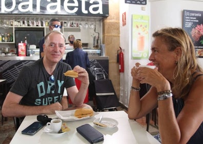 Imagen secundaria 1 - Varias tostadas del Bar Mercat y clientes de La Paraeta con un trozo de tortilla  de pescado dentro del bocata. 