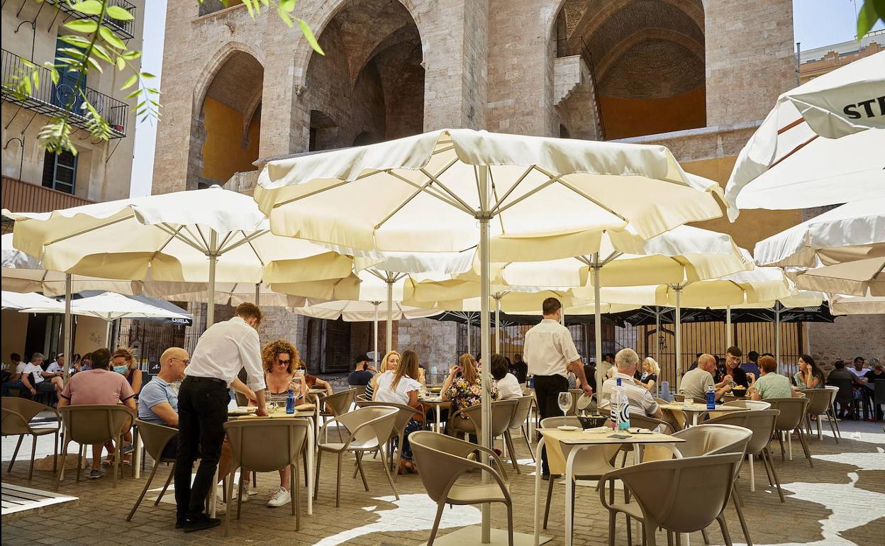 La terraza de un bar frente a las Torres de Quart en Valencia.