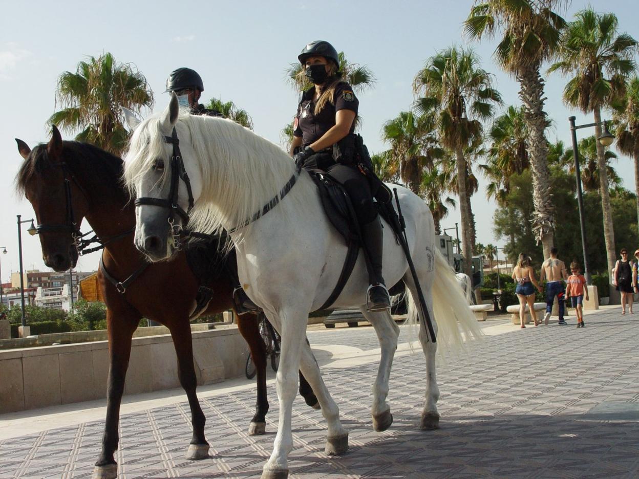 Dos policías de la Unidad de Caballería vigilan el paseo marítimo. toni blasco