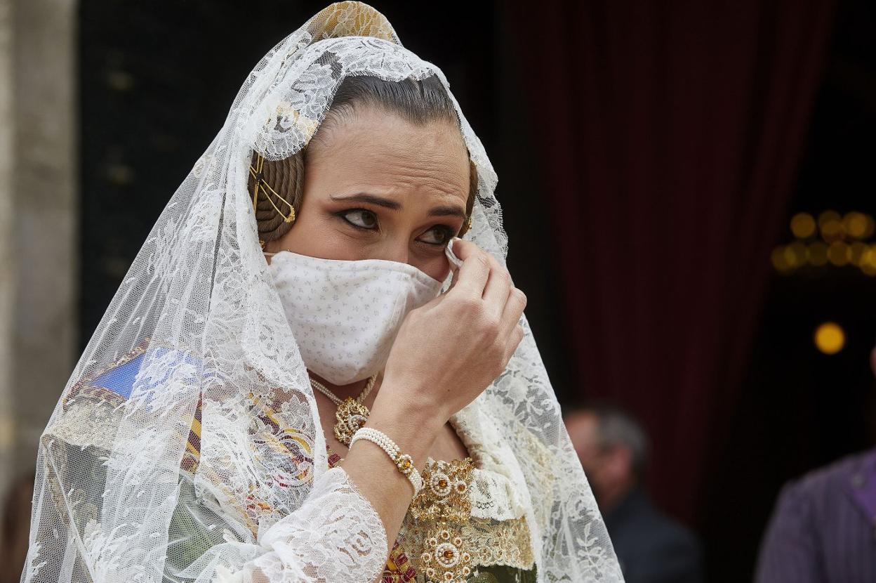 Una fallera se limpia las lágrimas tras llevar una ofrenda a la Basílica el pasado 19 de marzo. iván arlandis