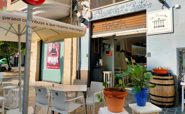 Imagen principal - Arriba, fachada del restaurante La Cocinita. Abajo a la izquierda, terraza del local. Abajo a la derecha, maceta situada junto a las mesas de la terraza. 