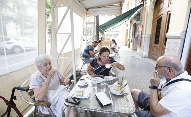 Personas tomando tazas de chocolate y horchata en la terraza de Fabián. 