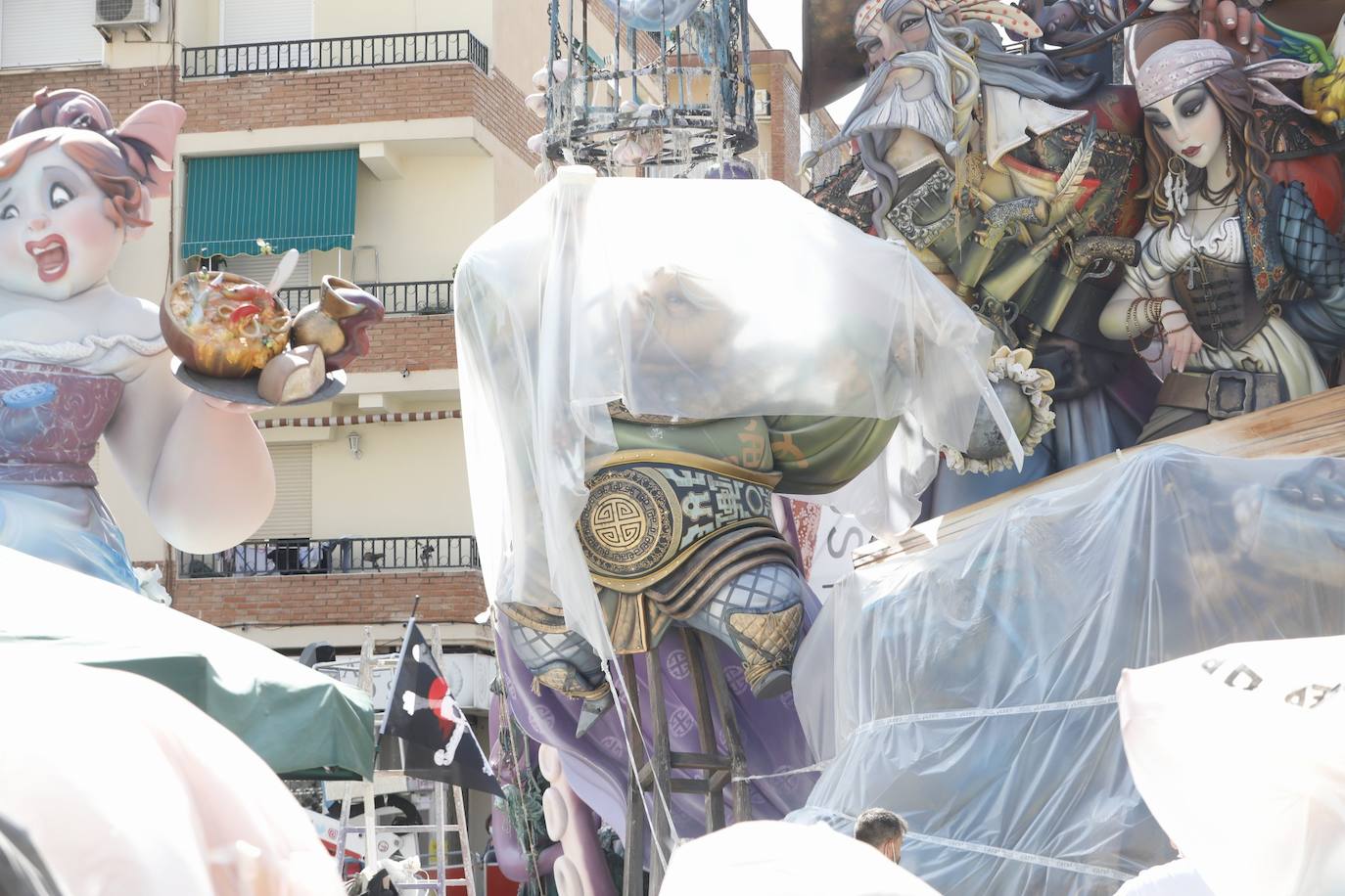 La lluvia acecha la plantà de las fallas. Muchos artistas han decidido cubrir sus monumentos con plástico ante los avisos de precipitaciones activados para los próximos días, para proteger las piezas de cualquier imprevisto.