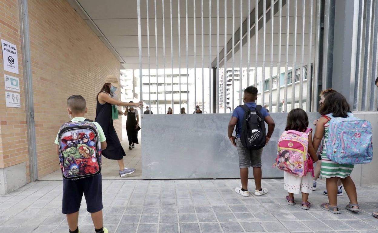 Niños esperan para entrar en la puerta de un colegio de Valencia, este miércoles.