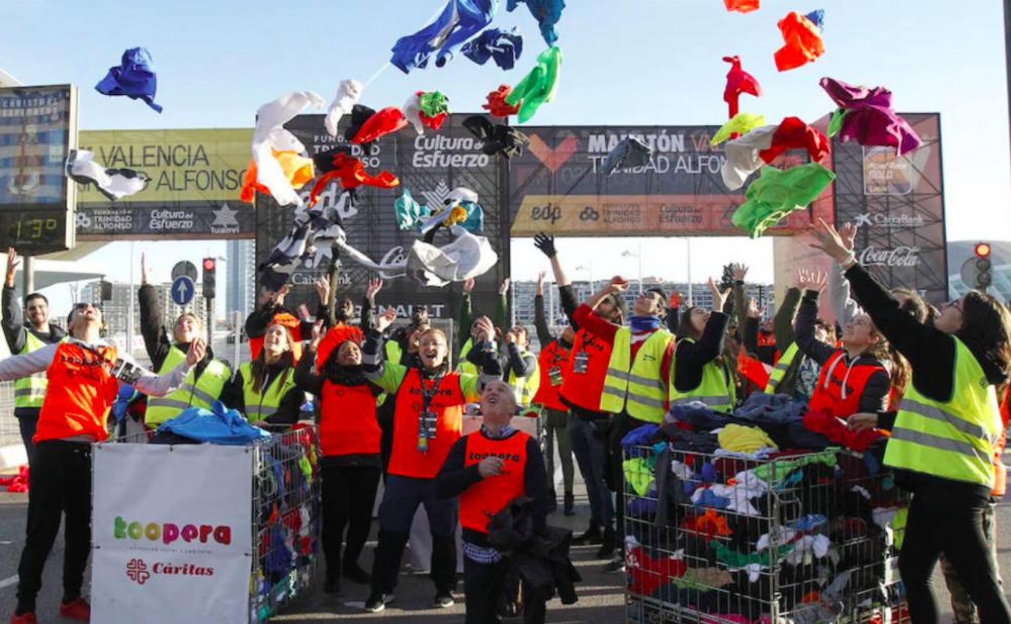 Voluntarios del Koopera Cáritas recogen prendas de los participantes del Maratón Valencia Trinidad Alfonso EDP de 2018 . 