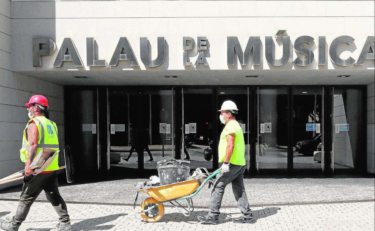 Dos operarios, en el Palau en junio de 2020 cuando se retiró el trencadís de la fachada, que se había desprendido en abril de 2018. 