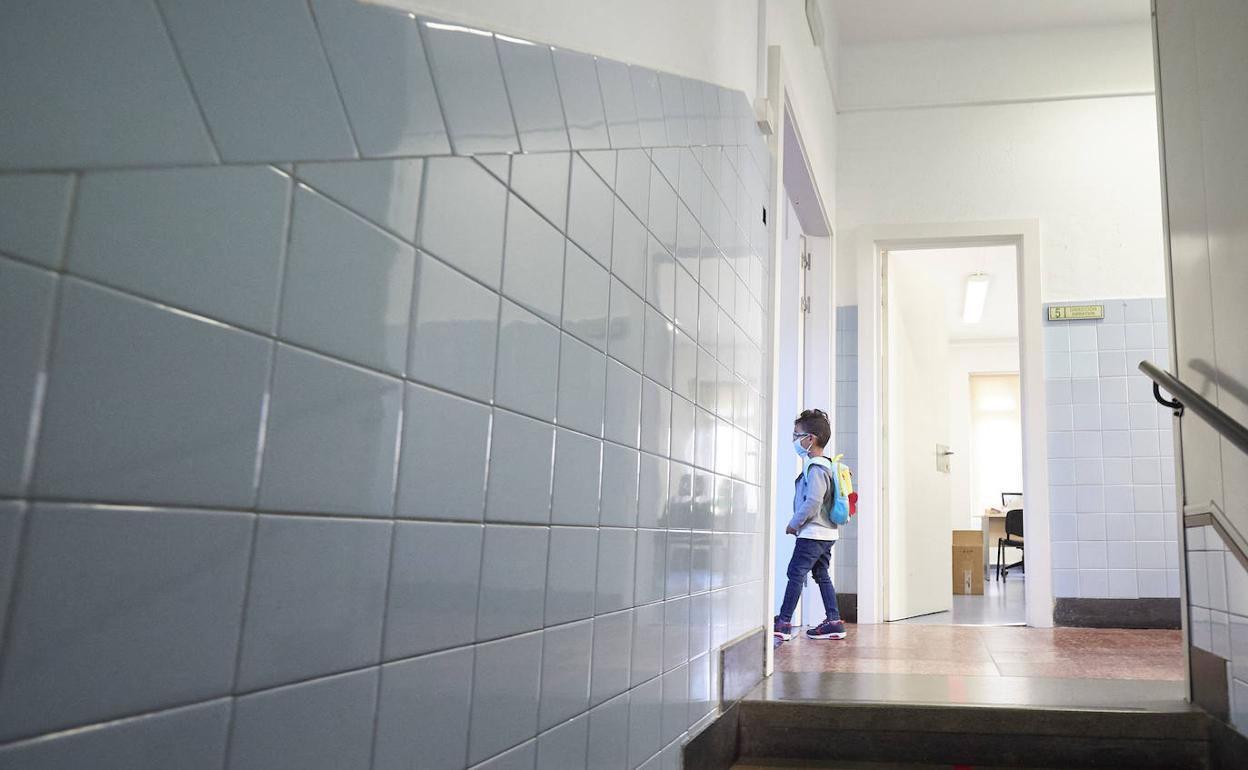 Un alumno entrando en su clase en el primer día de colegio. 