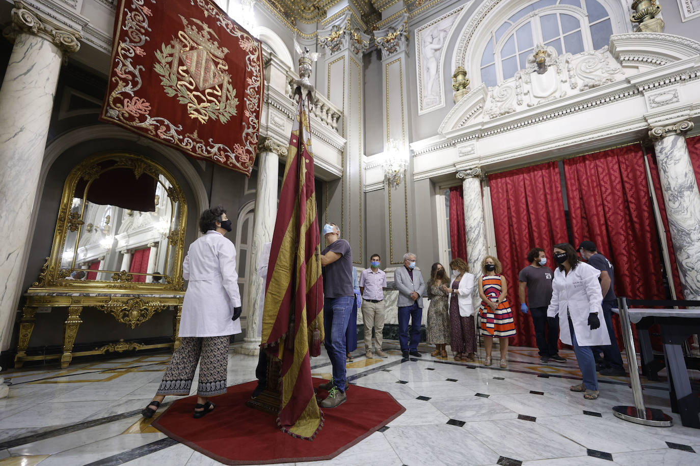 Cuatro meses de restauración devuelven el brillo a la enseña de 1928, que procesionará el 9 d'Octubre. Los expertos comprueban que el azul grisáceo que corona la pieza responde al mismo tono que muestra la bandera del siglo XVI