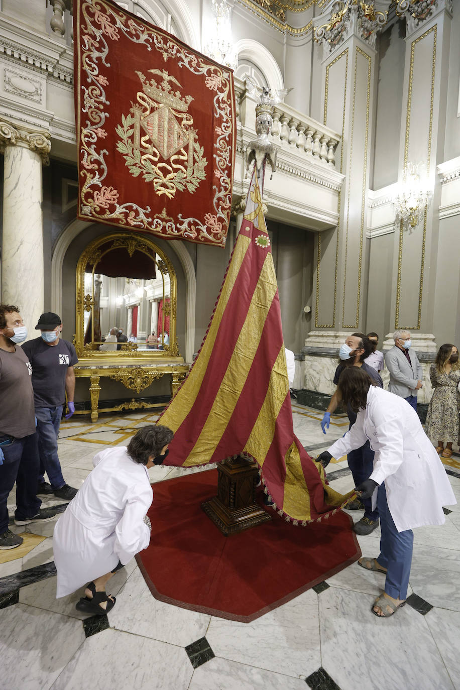 Cuatro meses de restauración devuelven el brillo a la enseña de 1928, que procesionará el 9 d'Octubre. Los expertos comprueban que el azul grisáceo que corona la pieza responde al mismo tono que muestra la bandera del siglo XVI