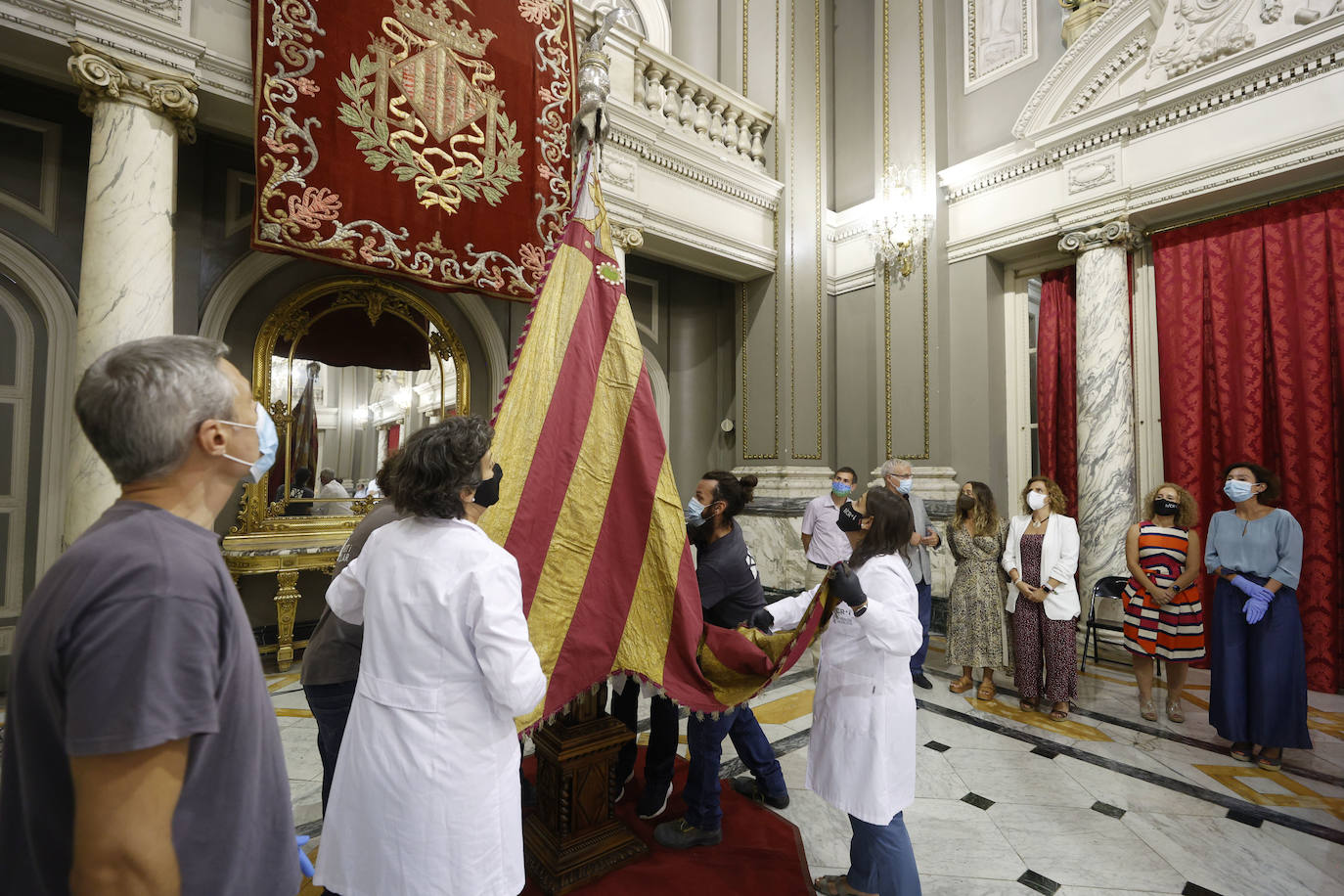 Cuatro meses de restauración devuelven el brillo a la enseña de 1928, que procesionará el 9 d'Octubre. Los expertos comprueban que el azul grisáceo que corona la pieza responde al mismo tono que muestra la bandera del siglo XVI