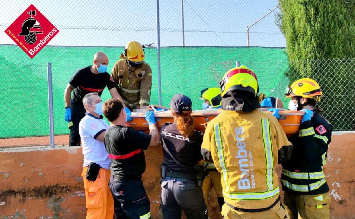 Los bomberos, los sanitarios y los agentes trasladan al herido en Dénia. 