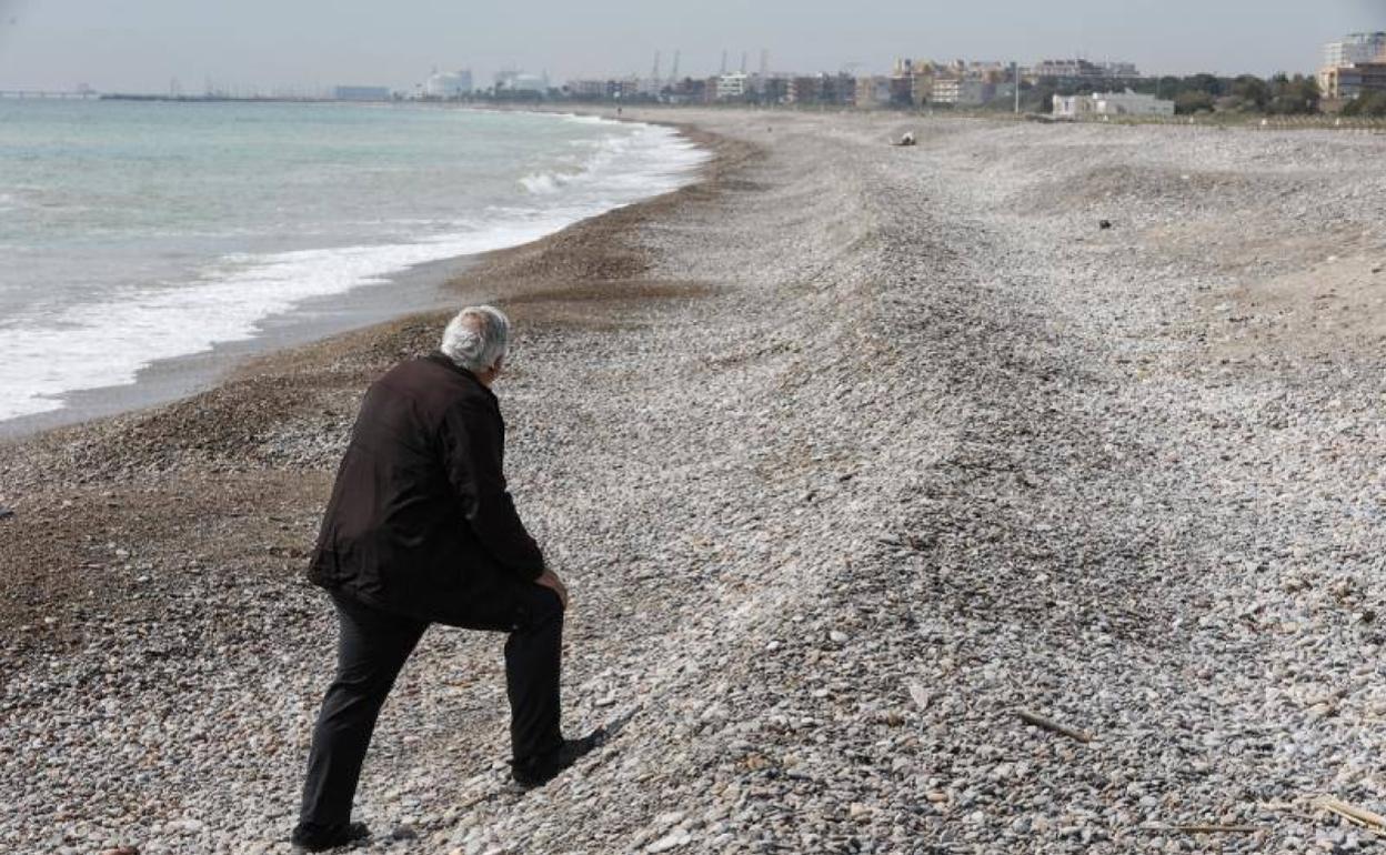 Un vecino en la playa en Sagunto en una zona con desnivel. 