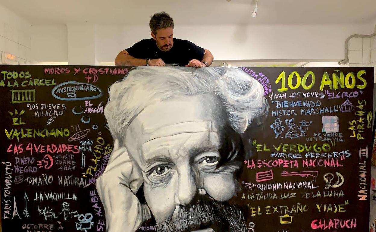 El artista René Mäkelä, con el mural de Berlanga. 