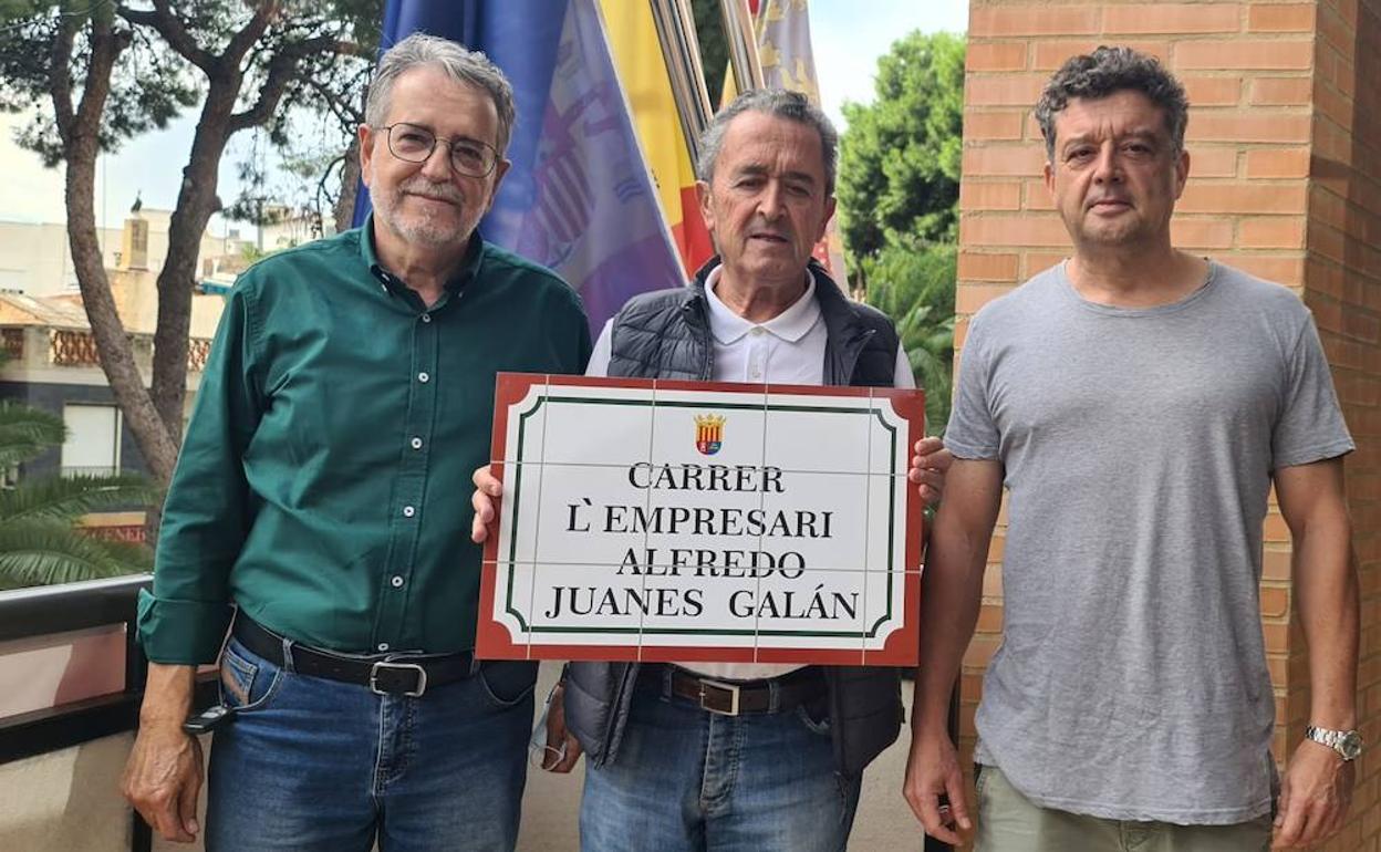 El hijo del empresario muestra la placa de la calle con el nombre, junto al alcalde, Ramón Marí. 