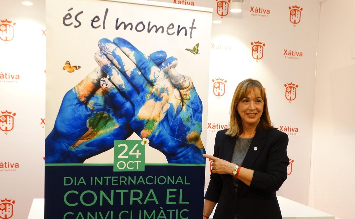 La concejala de Medio Ambiente de Xàtiva, junto al cartel conmemorativo del Día Contra el Cambio Climático. 