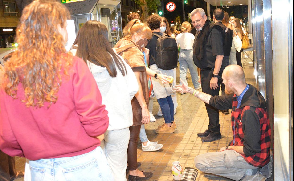 Estudiantes universitarios ofrecen comida a una persona sin hogar 