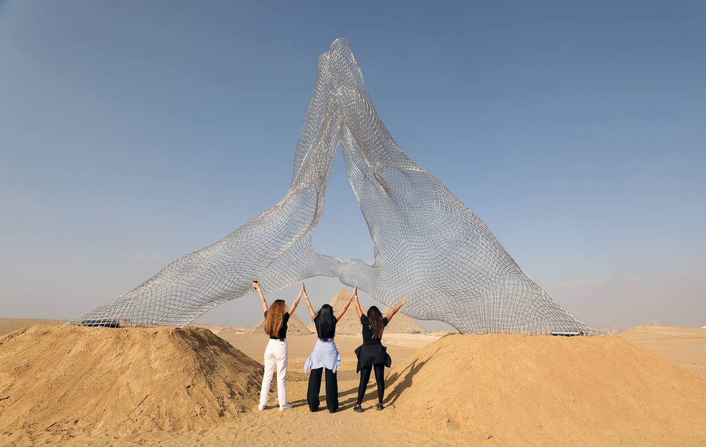 Las pirámides de Giza, Patrimonio de la Humanidad de la Unesco, cuentan con más de 4.000 años de antigüedad y son uno de los lugares más visitados del mundo. Pero ahora pueden verse como nunca antes, gracias a la exposición 'Forever Is Now', que recoge las obras de 10 artistas internacionales especialistas en la ilusión óptica, como Jean Rene (conocido como JR). 