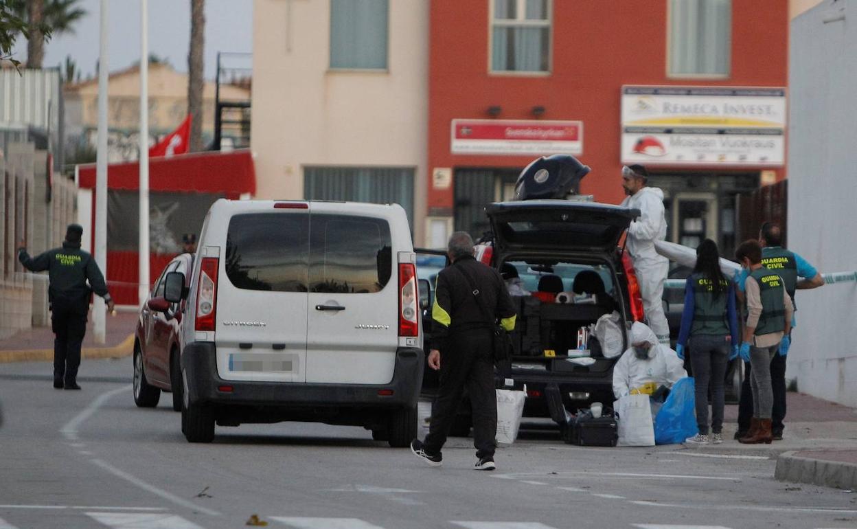 Agentes de la policía científica recogen muestras en la zona donde se han encontrado los restos humanos en un contenedor. 