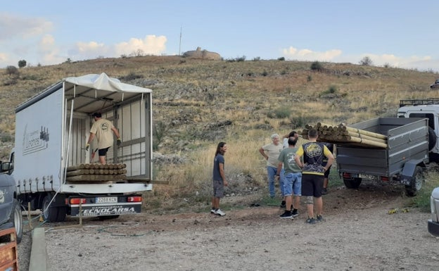 Imagen principal - Operarios, voluntarios y vehículos en la cima de la montaña. 