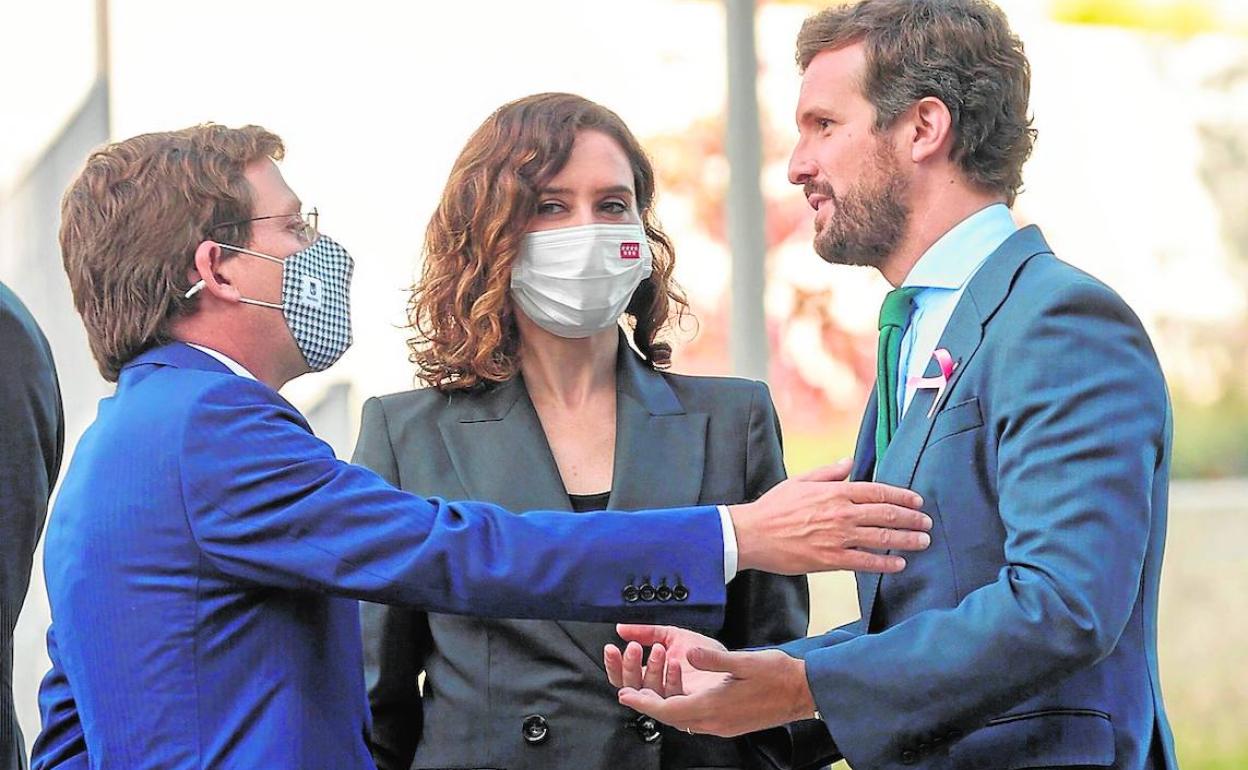 Casado conversa con Martínez-Almeida y Díaz Ayuso el pasado octubre durante un acto en Madrid. 